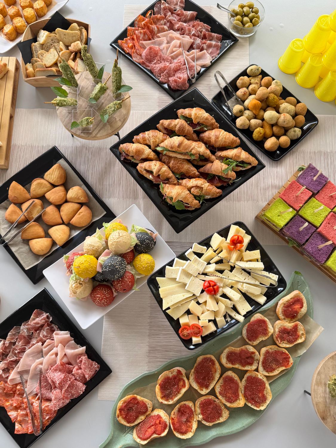 Buffet per una cerimonia visto dall'alto, con croissant salati, salumi, formaggi e stuzzichini, da Pito Pitù