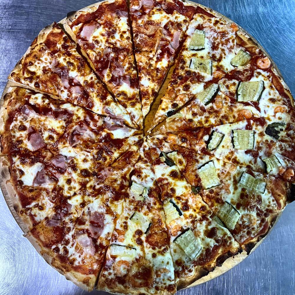 Pizza appena sfornata e tagliata del giropizza di Pito Pitù a Cabiate, metà prosciutto e metà con zucchine e gamberi