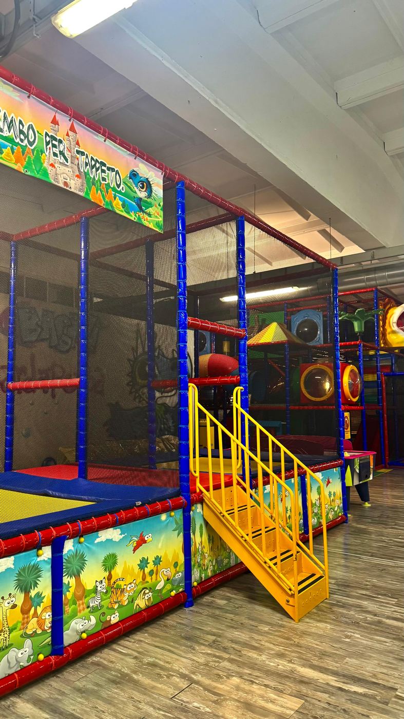 Tappeto elastico con rete di sicurezza nel parco giochi al coperto di Pito Pitù